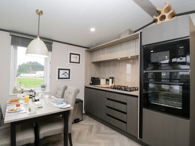 A kitchen and dining area with a table set for breakfast and modern appliances at Tiggywinkles in Chipping Norton