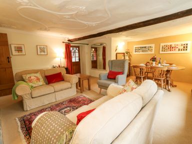 A living room with sofas and armchair and a dining table with chairs at The Elbow in Frampton