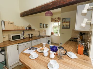 A kitchen with wooden countertops cups a blue teapot and a French press on the counter at The Elbow in Frampton