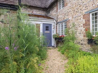 An exterior view with a front door and garden at The Elbow in Frampton