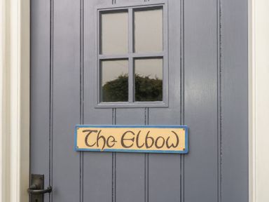 A door with a window and a sign that reads The Elbow at The Elbow in Frampton