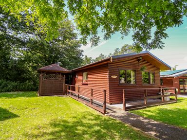 A cabin with a porch and garage at The Red in Llanerch Park near St Asaph
