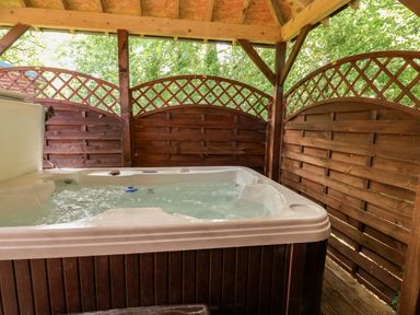A hot tub enclosed by wooden panels at The Red in Llanerch Park near St Asaph