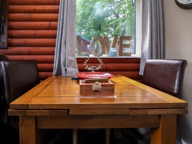 A dining room with a wooden table and love sign at The Red in Llanerch Park near St Asaph