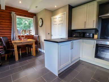 A kitchen with wooden table and chairs at The Red in Llanerch Park near St Asaph