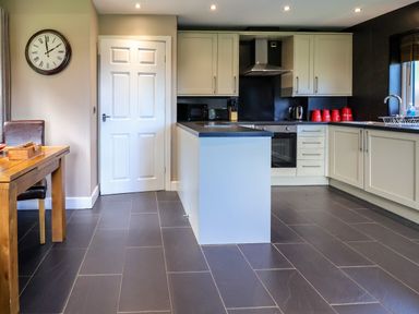 A kitchen with a table and chairs at The Red in Llanerch Park near St Asaph