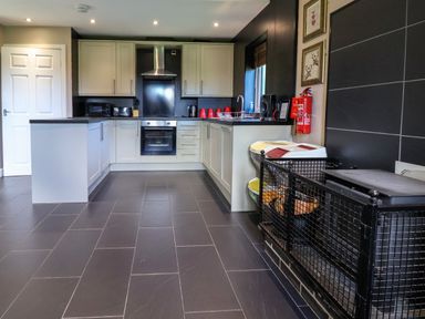 A kitchen with appliances and a dog crate at The Red in Llanerch Park near St Asaph