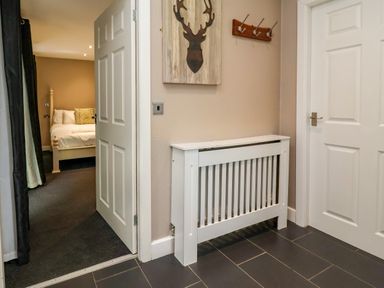 A hallway with a door and radiator at The Red, Llanerch Park near St Asaph