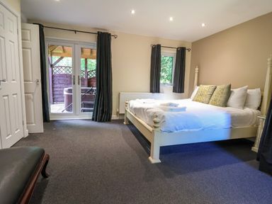 A bedroom with a bed and sliding doors at The Red in Llanerch Park near St Asaph