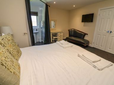 A bedroom with a bed and a couch at The Red in Llanerch Park near St Asaph