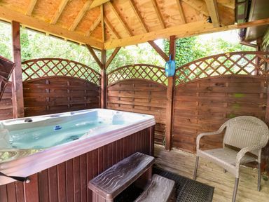 An outdoor area with a hot tub and a chair at The Red in Llanerch Park near St Asaph