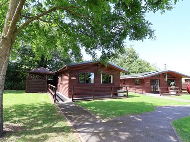 A log cabin with surrounding garden space at The Red in Llanerch Park near St Asaph