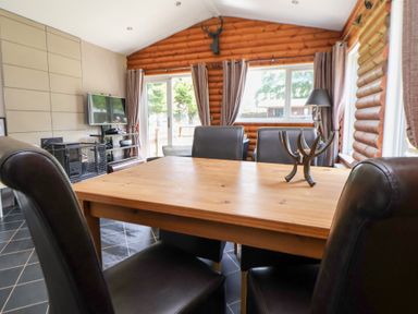 A dining room with a table and chairs at The Fallows in Llanerch Park near St Asaph