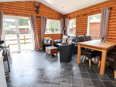 A snug area with seating and a dining table at The Fallows in Llanerch Park near St Asaph
