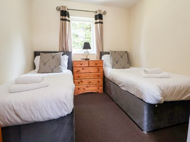 A bedroom with two beds and drawers at The Fallows in Llanerch Park near St Asaph