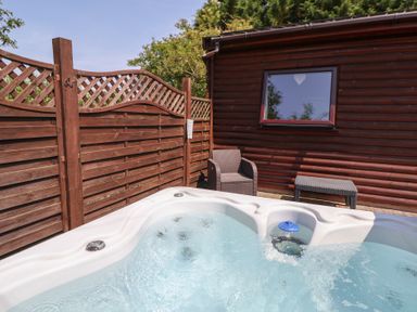 A hot tub and seating area in a garden at The Fallows near Llanerch Park near St Asaph