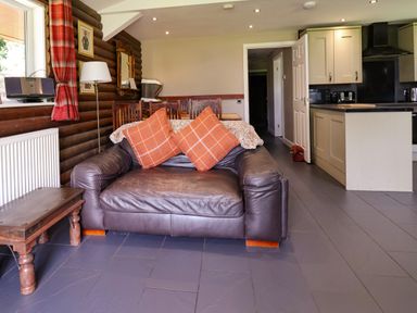 A living room with a sofa and coffee table at The Roe in Llanerch Park near St Asaph