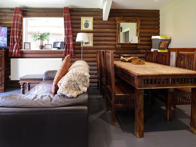 A dining room with a table and chairs at The Roe in Llanerch Park near St Asaph