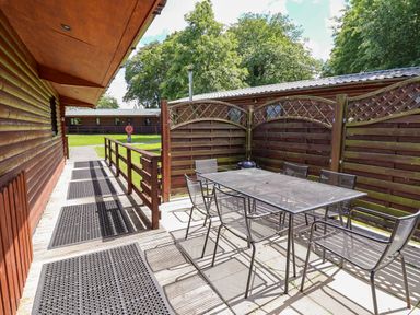 A patio with a table and chairs at The Roe Llanerch Park near St Asaph