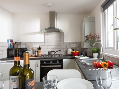 A kitchen with a stove microwave kettle knife block and vegetables on the counter at Wheal Jewel Lodge in Wendron near Helston