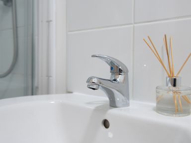 A bathroom sink with a chrome faucet and a reed diffuser on the side at Wheal Jewel Lodge in Wendron near Helston