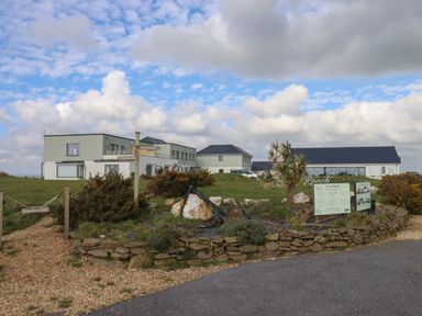 A building complex with signs and a stone-bordered garden area at 5 Ocean Reach in Bolberry