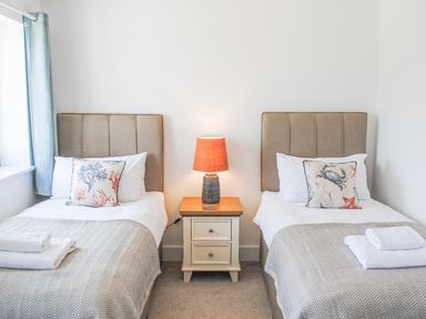 A bedroom with two single beds and a nightstand with a lamp at 5 Ocean Reach in Bolberry