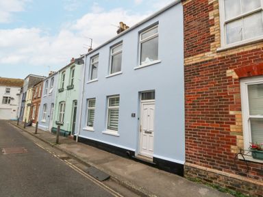 A row of terraced houses with painted facades along a street at Beachaven in Weymouth