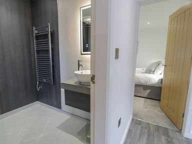 A bathroom with a sink and towel rack adjacent to a bedroom with a bed at Classic Lodge 25 in Dyserth