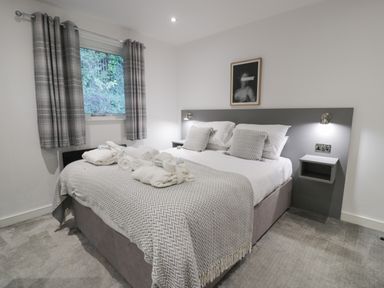 A bedroom with a double bed and folded towels on the bed at Luxury Lodge 53 in Dyserth