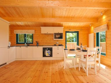 A kitchen with a dining table and four chairs at Owl Lodge in Menheniot