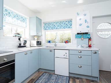 A kitchen with light blue cabinets microwave coffee maker and oven at The Old Coastguard Tower Buncrana County Donegal