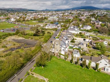 An aerial view of a town with houses roads green fields and hills in the background at The Old Coastguard Tower Buncrana in Buncrana County Donegal