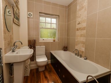 A bathroom with a bathtub shower toilet and sink at The Lobster Pot in Weymouth