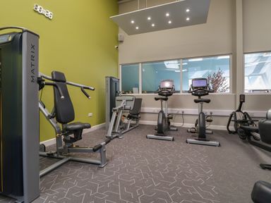 A gym with exercise machines including stationary bikes and weight machines at Lodge 9 in St Asaph