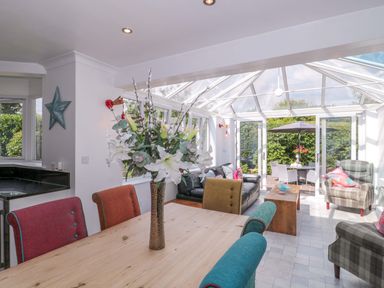 A conservatory with a dining table and chairs at No 8 Burnham-on-Sea
