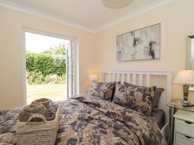 A bedroom with a bed and open door leading to the garden at No 8 Burnham-on-Sea