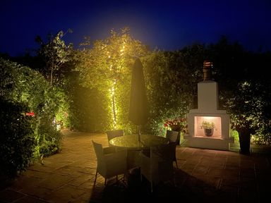 A garden with a table, chairs, and fireplace at No 8 in Burnham-On-Sea