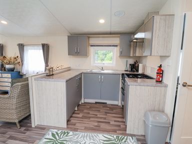 A kitchen with gray cabinets and a gas stove at The Hoot in Great Finborough near Stowmarket