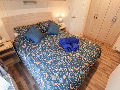 A bedroom with a bed and towels at The Hoot in Great Finborough near Stowmarket