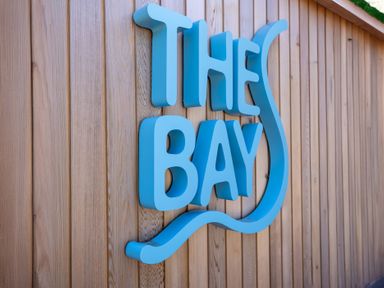 A sign that says THE BAY on a wooden wall at Lodge 65 at Riviera Bay Coastal Retreat Brixham