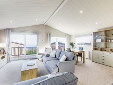 A living room with a sofa and dining area at Lodge 65 at Riviera Bay Coastal Retreat Brixham