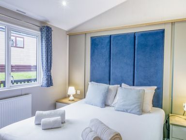 A bedroom with a bed and decorative pillows at Lodge 65 at Riviera Bay Coastal Retreat in Brixham