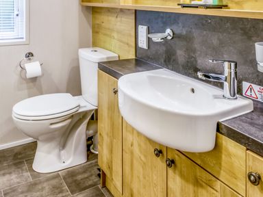 A bathroom featuring a toilet and sink at Lodge 65 at Riviera Bay Coastal Retreat Brixham