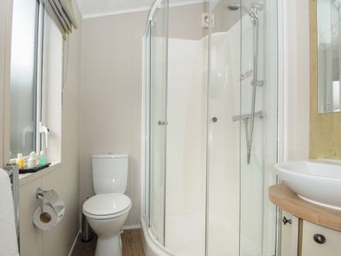 A bathroom with a toilet shower enclosure and sink at Lodge 67 at Riviera Bay Coastal Retreat in Brixham