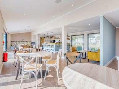 An indoor dining area with tables and chairs at Lodge 67 at Riviera Bay Coastal Retreat Brixham