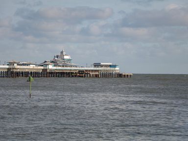 A pier extending into the sea under a cloudy sky