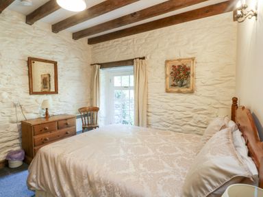 A bedroom with a bed and dresser at Royal Oak Farm Cottage in Betws-y-Coed