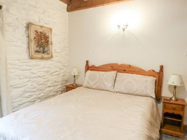 A bedroom with a bed and bedside tables at Royal Oak Farm Cottage Betws-y-Coed