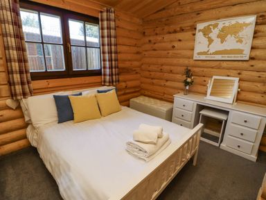 A bedroom with a bed and pillows next to a desk with a mirror and a chest at Starwood in Felton